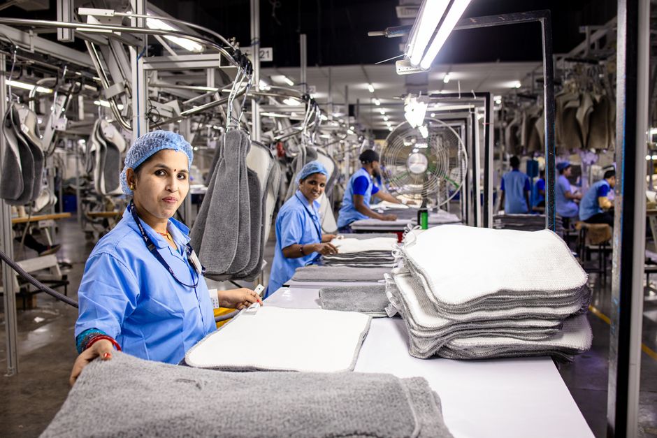 Female factory workers in India working on a textile production line, showcasing teamwork and efficiency.