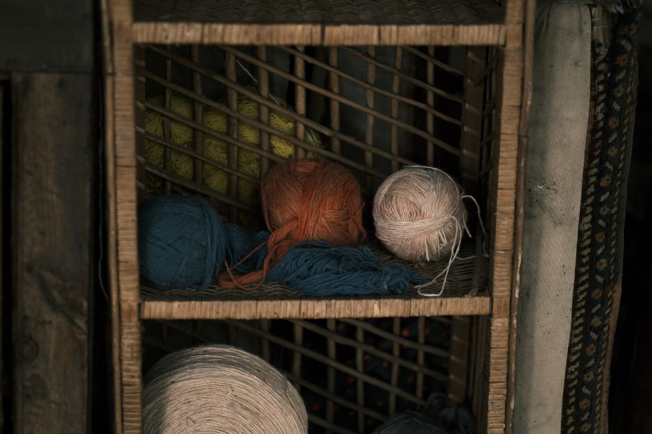 Vibrant yarn balls in rustic wooden shelf setting, capturing the essence of crafting materials.